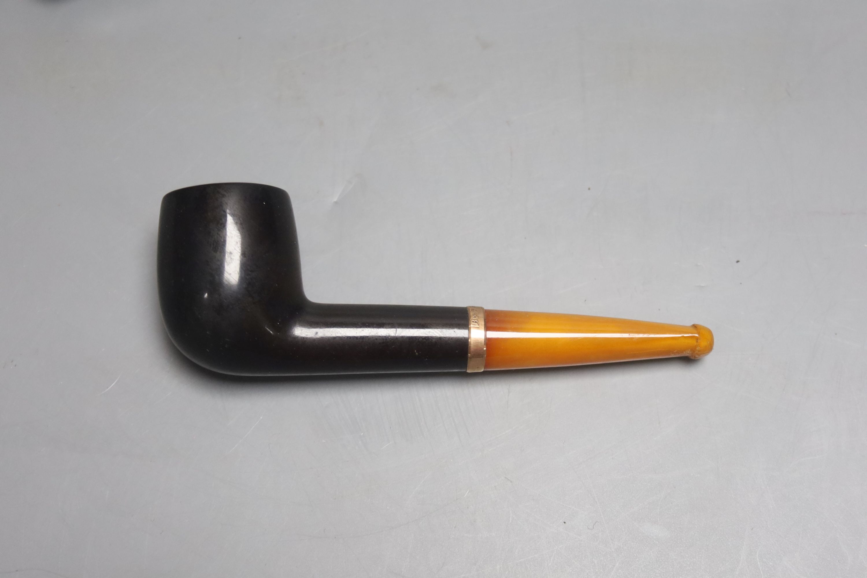 A cased pipe with amber mouthpiece and 9ct gold collar.